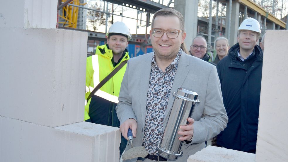 Mit Mörtel bedeckte Barßels Bürgermeister die Zeitkapsel, die in einen hohlen Ziegel einer Wand des Neubaus eingebettet wurde, und legte damit offiziell den Grundstein für Barßels neues Bürgerhaus mit Verwaltungstrakt. Fotos: Fertig