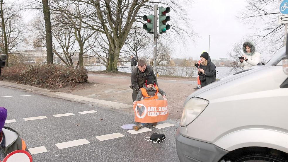 Ein Autofahrer zieht eine der Aktivistinnen von der Kennedybrücke. Foto: Lenthe-Medien/Reimer