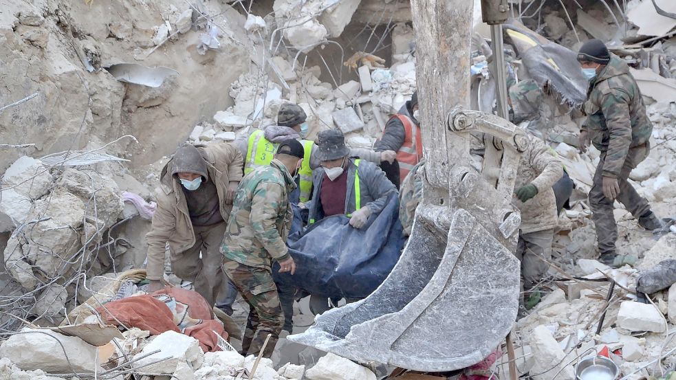 Rettungskräfte suchen nach Überlebenden in den Trümmern eines zerstörten Gebäudes im Stadtteil Bustan al-Basha in Aleppo. Foto: Stringer/XinHua/dpa