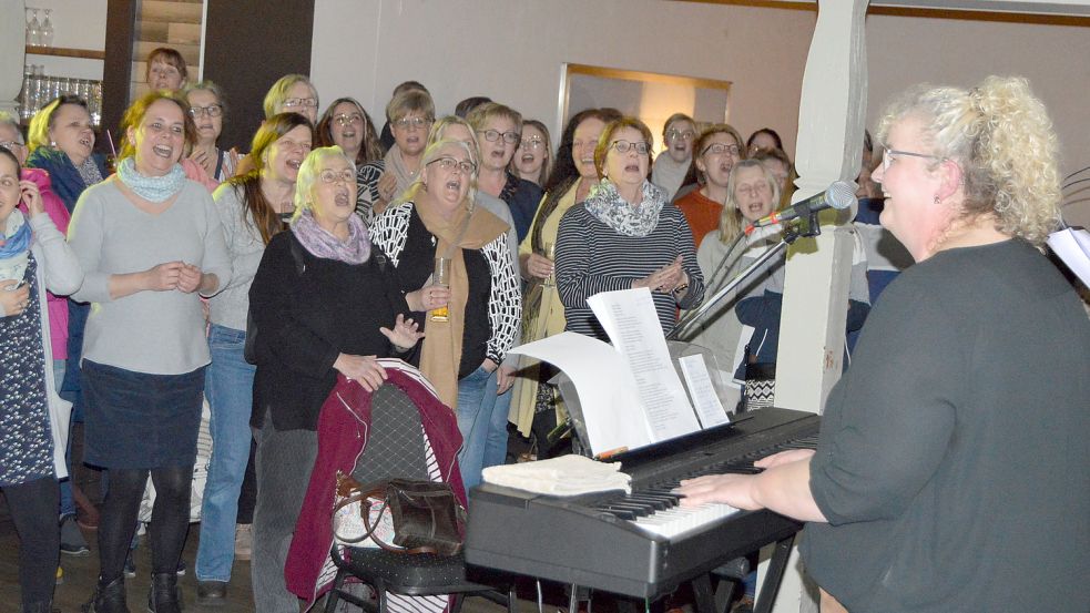 Chorleiterin Gesa Goudschaal begleitete die rund 250 Frauen am Mikrofon und Keyboard beim Rudelsingen. Fotos: Weers