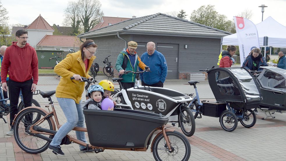 Maren Lüger-Hobler unternahm mit einem Lastenrad gleich einmal eine kleine Spritztour. Ihre Kinder Jonte und Merle hatten ihren Spaß. Vater Dennis (links) schaute interessiert zu. Foto: Weers