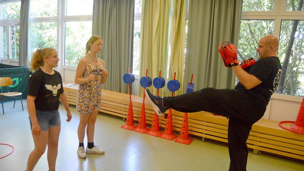 Selbstverteidigungstraining durch Sportakademie Dahlmann aus Papenburg. Till Dahlmann erklärt zwei jungen Mädchen Verteidigungstechniken. Foto: Weers