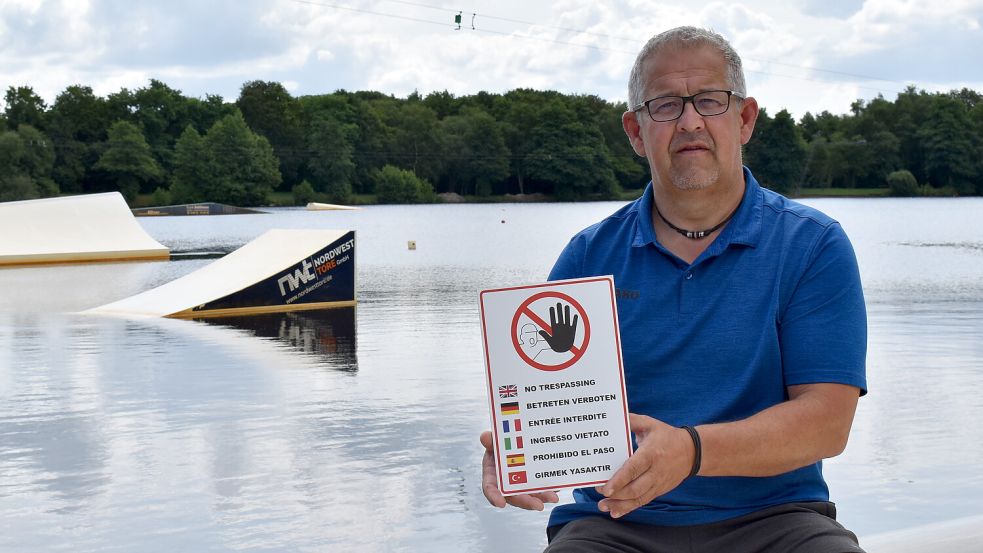 Frank Junker, Vorsitzender des Wassersportclubs Idafehn, hat mehrsprachige Schilder gekauft, mit denen er darauf hinweist, dass das Klettern auf Hindernisse und Masten streng verboten ist. Fotos: Zein