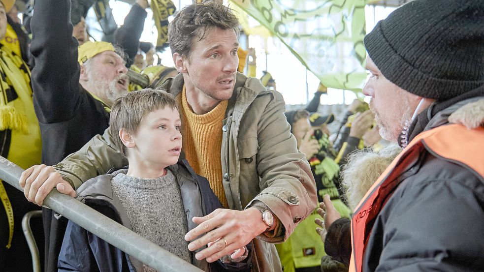 Szene aus dem neuen Film „Wochenendrebellen“: Jason (Cecilio Andresen) und Vater Mirco (Florian David Fitz) flüchten vor der Enge auf der Dortmunder Südtribüne. Ein Ordner stellt sich in den Weg. Foto: Leonie Studios