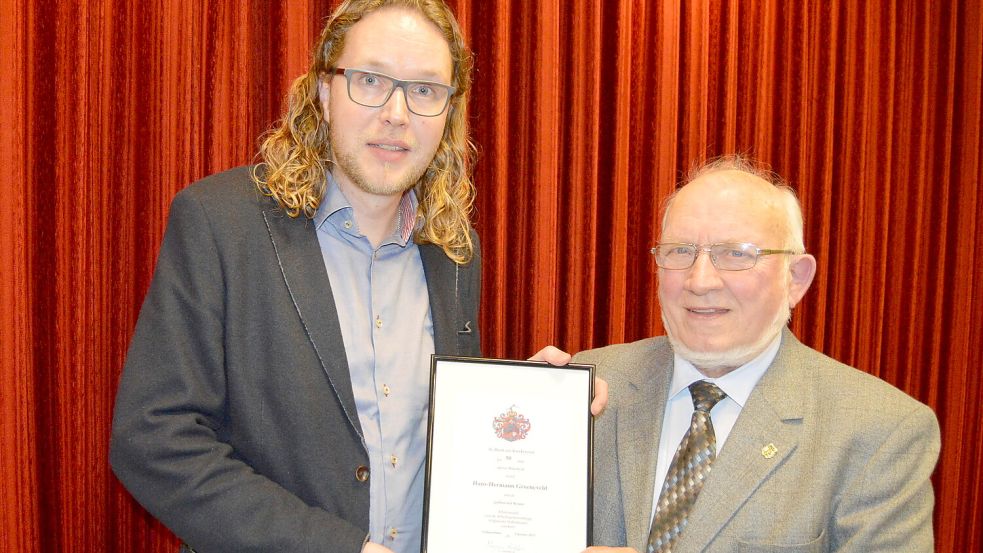 Für seine langjährigen Verdienste und Mitarbeit als Schauspieler des plattdeutschen Theaters wurde Hans-Hermann Groeneveld (rechts) mit der Ehrennadel mit goldenem Kranz sowie einer Urkunde ausgezeichnet. Die Auszeichnung nahm Steffen Kolthoff (links), Beisitzer der Arbeitsgemeinschaft Ostfriesischer Volkstheater im Landkreis Leer, vor. Foto: Weers