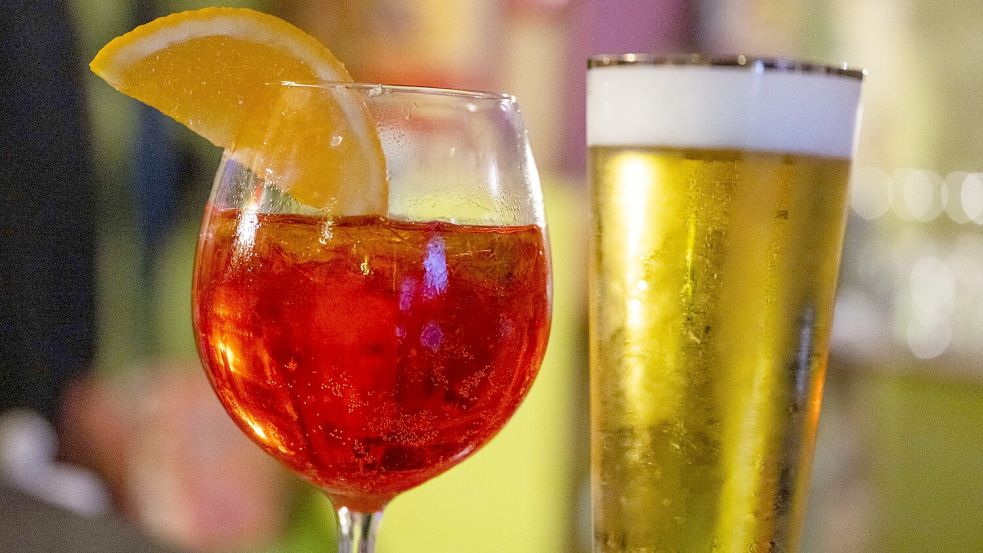 In einer Bar stehen ein Glas Aperol Spritz und ein Glas alkoholfreies Bier auf dem Tresen. Foto: dpa/Christophe Gateau