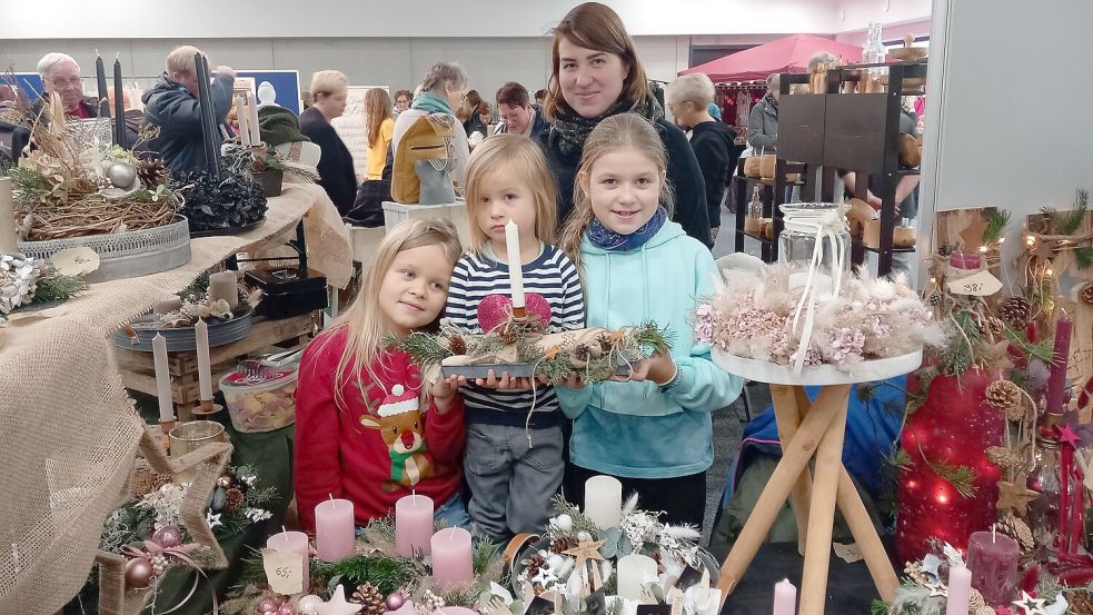 Leyntje Tausendfreund (34) aus Ostrhauderfehn ist mit ihren Kindern Taya (7), Kalea (4) und Feenia (10) zum ersten Mal mit selbstgemachten Weihnachtskränzen und Gestecken beim Kreativmarkt dabei. Foto: Scherzer