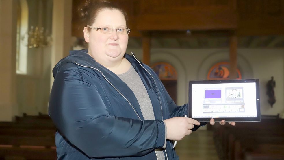 Daniela Albers, Mitarbeiterin im Pfarrbüro der katholischen Kirchengemeinde St. Ansgar, Barßel, zeigt auf einem Tablet die neuen, virtuellen Möglichkeiten. Dank Kamera und Internet ist es ab Heiligabend möglich, die Gottesdienste aus der Kirche Ss. Cosmas und Damian live im Internet zu verfolgen. Foto: Passmann