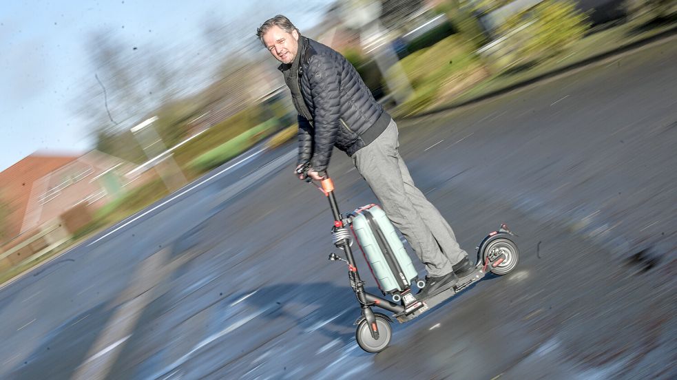 Den Koffer auf dem E-Scooter hat Arno Lübbers mithilfe seiner Erfindung fixiert. Foto: Ortgies