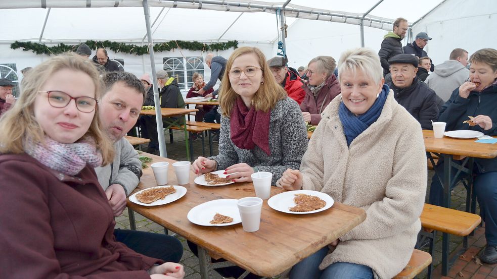 Schmecken lassen sich die leckeren Speckendicken des Möhlenkrings Rhaude auch (von links) Lea und Jörg Spieker sowie Carina Spieker und Eva Wessels. Die Familie kommt aus Rhauderfehn und Idafehn. Sie hat sich zuerst mit Speckendicken für zu Hause eingedeckt, bevor sie im Zelt an der Mühle noch gemütlich am Tisch mit weiteren Speckendicken Platz genommen hat. „Die schmecken immer lecker!“, versichert Jörg Spieker. Davon könne er bestimmt vier Stück locker schaffen. Foto: Fertig