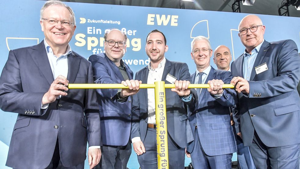 Niedersachsens Ministerpräsident Stephan Weil (SPD) (von links), Umweltminister Christian Meyer (Grüne), SPD-Landtagsabgeordneter Nico Bloem, Landrat Matthias Groote (SPD), Vorstands­vorsitzender der EWE Stefan Dohler (hinten) und Jemgums Bürgermeister Hans-Peter Heikens (parteilos) drehen den „Schieber-Schlüssel für die Energiewende“. Foto: Ortgies