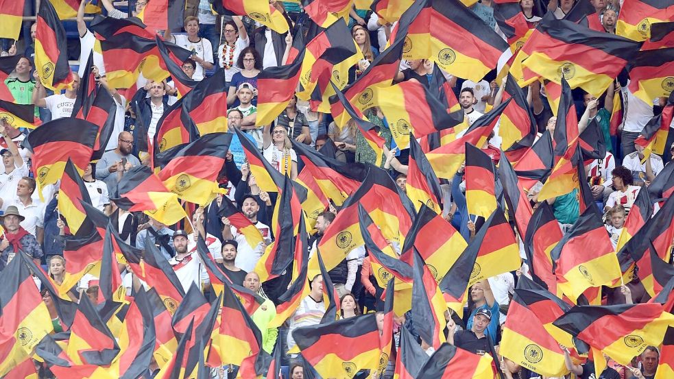 Fans schwenken Deutschlandfahnen auf der Tribüne. Foto: Uli Deck/dpa