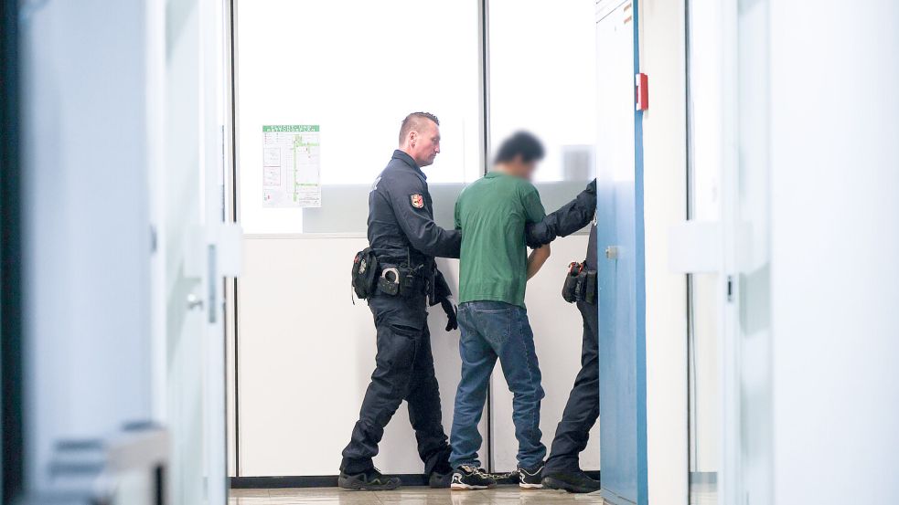 Ibrahim A. wird am Tag des Urteils von Justiz-Personal durch die Gänge im Landgericht Itzehoe geführt. Foto: Christian Charisius/dpa