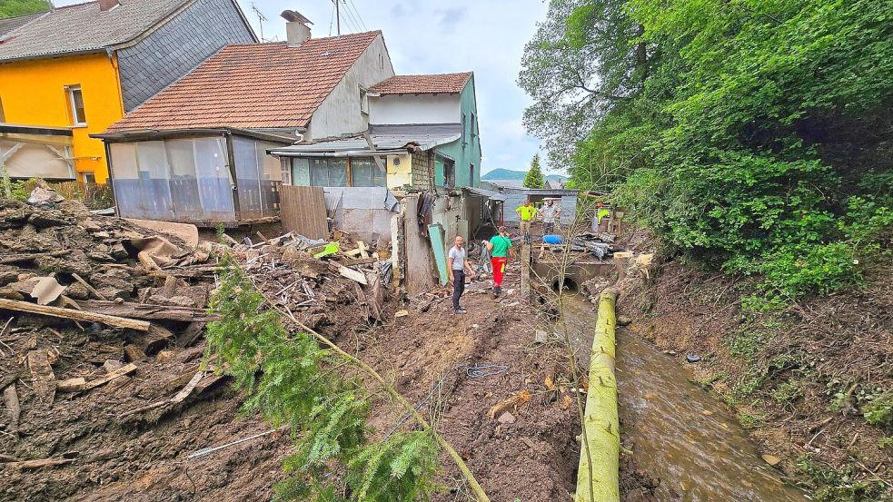 Aufräumarbeiten nach dem Hochwasser in Kirn-Sulzbach. Foto: Sebastian Schmitt/dpa