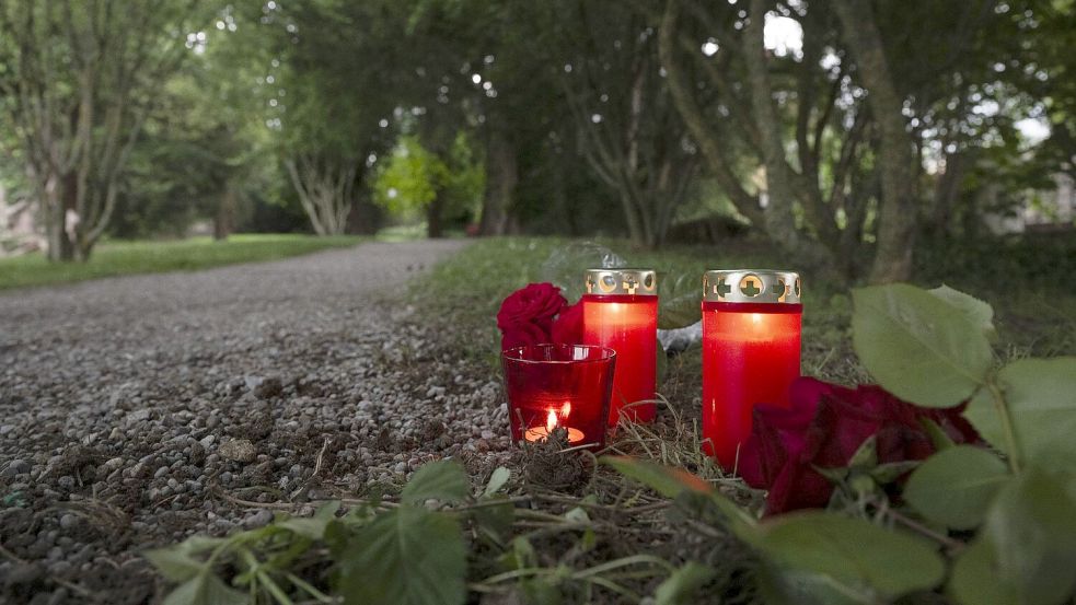 Blumem und Kerzen liegen im Park an dem Tatort im schweizerischen Männedorf. Foto: Ennio Leanza/KEYSTONE/dpa