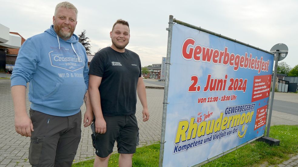 Frank Plümer (links) und Tim Ehmann haben die Banner aufgestellt, die auf das Gewerbegebietsfest hinweisen. Das erste bauten sie gleich am Eingang des Gewerbegebietes an der Schuhmacherstraße in Rhaudermoor auf. Foto: Fertig