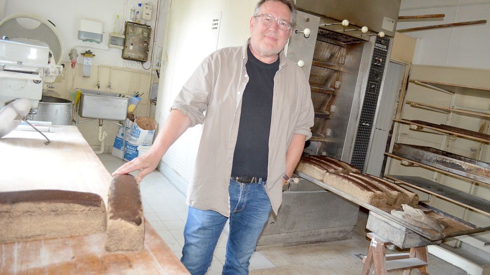 Bäckermeister Siegbert Kordes in seiner Backstube mit einigen Schwarzbroten. Deren Geheimzutat ist neben reinem Roggenvollkornschrot die Zeit, die er dem Gebäck lässt. Foto: Fertig