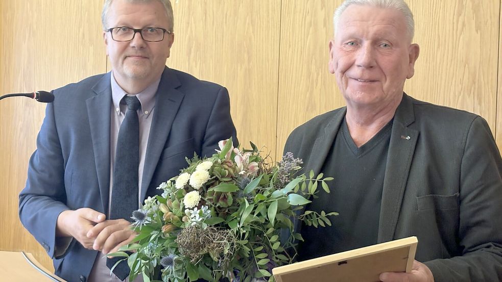 Mit einer Urkunde und Blumen verabschiedete Bürgermeister Theo Douwes den Christdemokraten Hans-Dieter Weichers (rechts). Foto: Hellmers