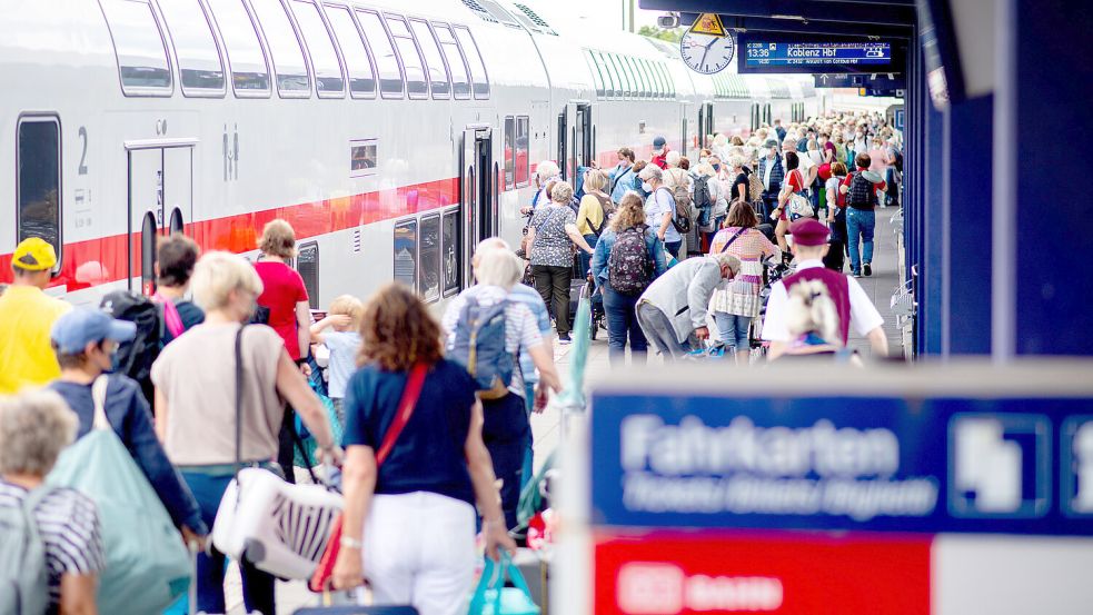 Zahlreiche Touristen gehen über den Bahnsteig Norddeich-Mole, um in einen IC der Deutschen Bahn einzusteigen. Foto: Dittrich/DPA