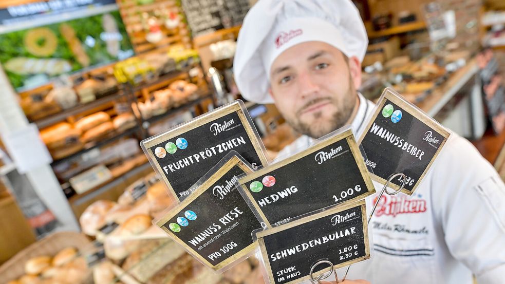 Milan Rämmele zeigt einige der ausgefallenen Backwaren-Namen, die es bei der Bäckerei Ripken gibt. Foto: Ortgies