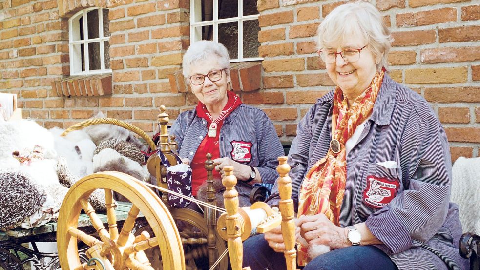 Die Spinn-Frauen zeigen, wie man aus Wolle Garn herstellt.