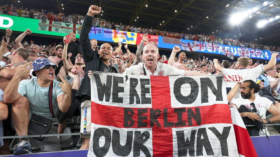 Ein England-Fan jubelt mit einem Banner mit der Aufschrift „We‘re on our way - Berlin“ über den Finaleinzug seiner Mannschaft. Foto: dpa/Friso Gentsch