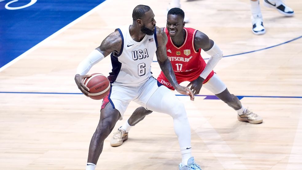 Basketball-Stars unter sich: James gegen Schröder. Foto: Adam Davy/PA Wire/dpa