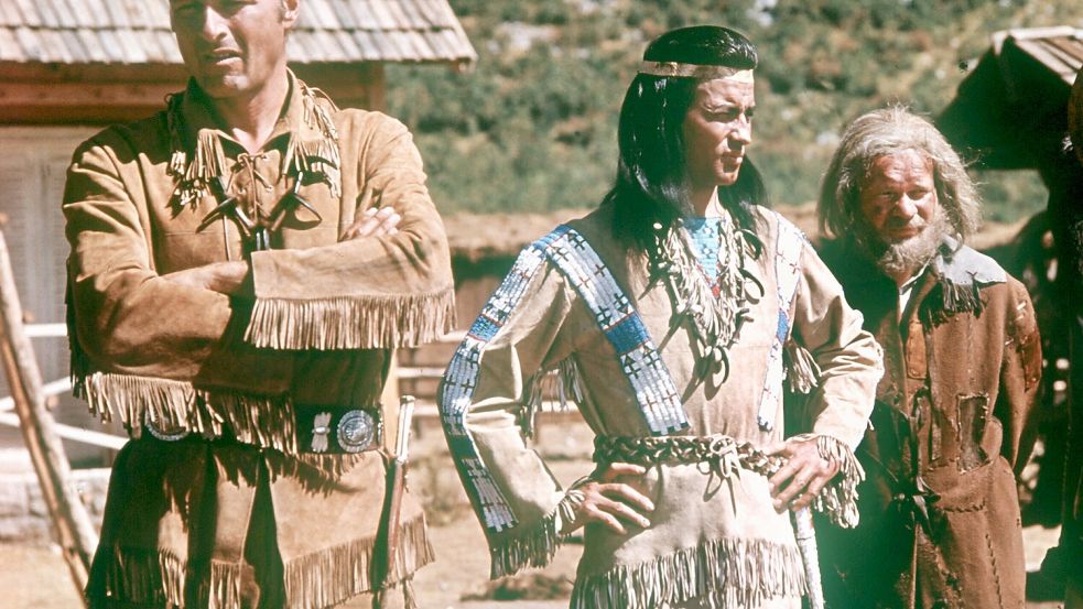 Friedensbotschafter im Gewand der Actionhelden? Die Schauspieler Lex Barker als Old Shatterhand, Pierre Brice als Winnetou und Ralf Wolter als Sam Hawkens (l-r) in einer Szene des Films „Der Schatz im Silbersee“. Foto: dpa/picture-alliance