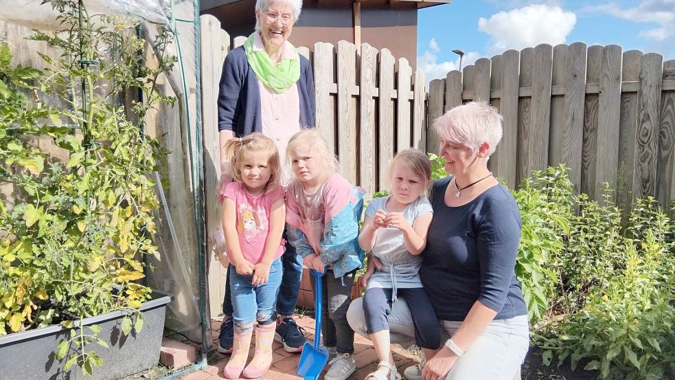 Thea Gruben (vorne, von Links), Merle Gronowski und Antonia Nowak, alle drei Jahre alt und von der Fledermausgruppe mit Gruppenleiterin Heike Hessenius gärtnern gerne mit ihrer Gartenoma Annegret (hinten). Foto: Scherzer