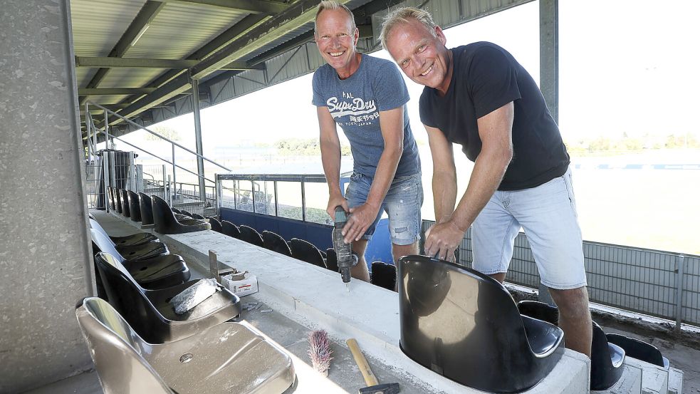 Eckhard Sanders (links) und Jens Kalvelage (rechts) bringen die neuen Sitze an. Fotos: Doden, Emden