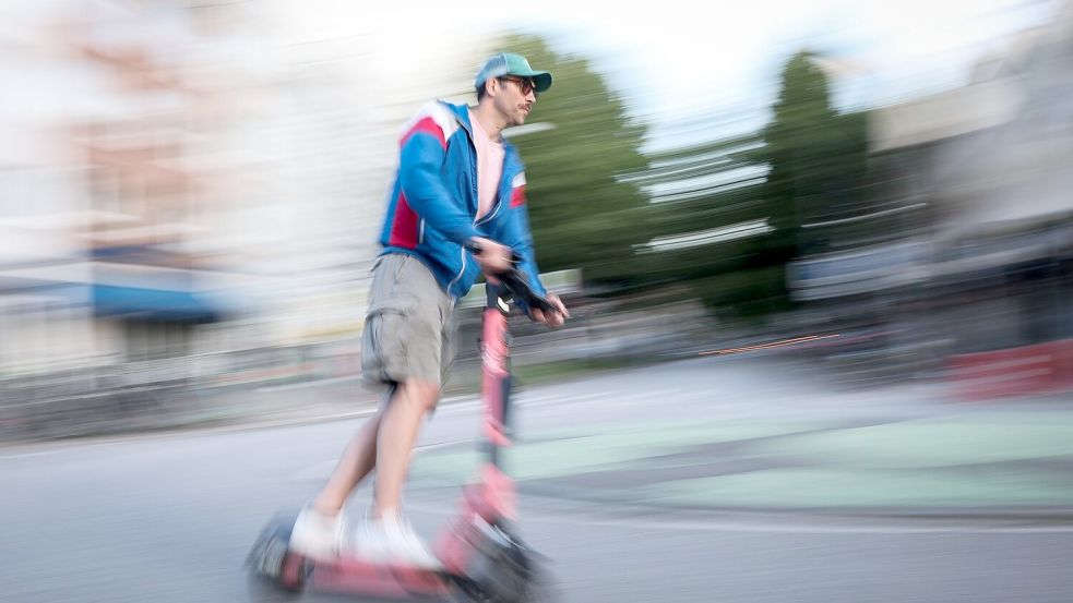 Ein Mann in Hamburg ist auf einem E-Scooter unterwegs. Die Bundesregierung plant neue Regeln zu E-Scootern. Foto: Christian Charisius/dpa