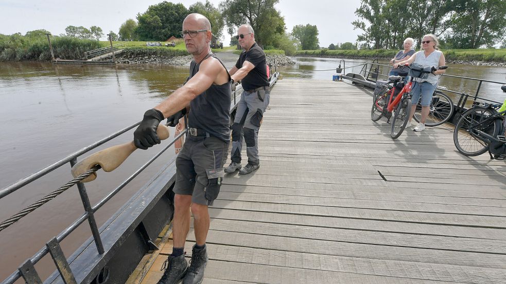 In dieser Woche wurde das Wetter besser. Das nutzten Radfahrer für eine Tour mit der Pünte. Die Fährmänner Ingo Wellbrock (vorne), Dieter Hinz und Vitalii Dunits (verdeckt) zogen die Fähre über das Wasser. Foto: Ortgies