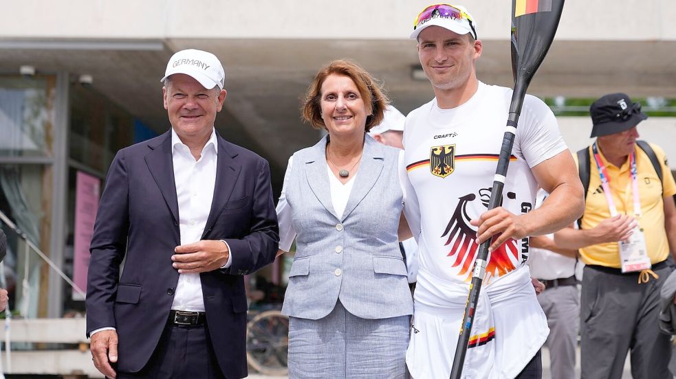 Bundeskanzler Olaf Scholz (l) und seine Frau Britta Ernst lassen sich mit Olympiasieger Tom Liebscher-Lucz fotografieren. Foto: Lindsey Wasson/AP/dpa