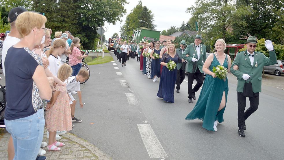 Beim Umzug durch das Dorf waren viele Einwohner und Gäste dabei. Sie applaudierten der neuen Königin Amke Bokelmann (rechts) und dem Königsthron. Fotos: Weers