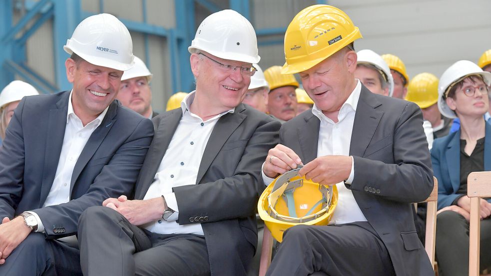 Gute Laune in Papenburg: Bundeskanzler Olaf Scholz (rechts) zeigt Niedersachsens Ministerpräsident Stephan Weil (Mitte), wie man seinen Schutzhelm der Kopfgröße anpasst – und Wirtschaftsminister Olaf Lies (alle SPD) hat viel zu lachen. Foto: Ortgies