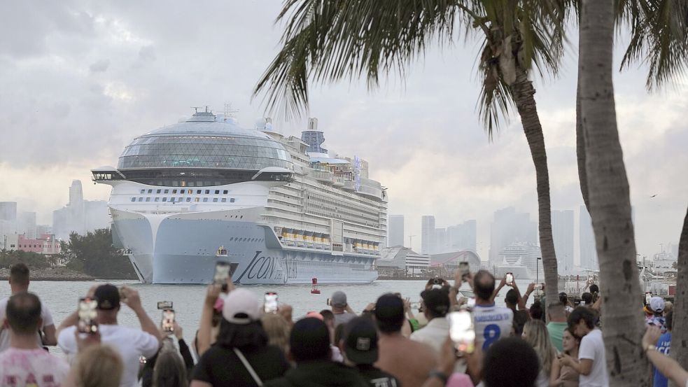 Traumurlaub Ende Januar dieses Jahres in Miami Beach: Menschen filmen vom South Pointe Park aus, wie die „Icon of the Seas“, das größte Kreuzfahrtschiff der Welt, auf seiner ersten öffentlichen Kreuzfahrt aus Port Miami herausfährt. Foto: Blackwell/AP/DPA