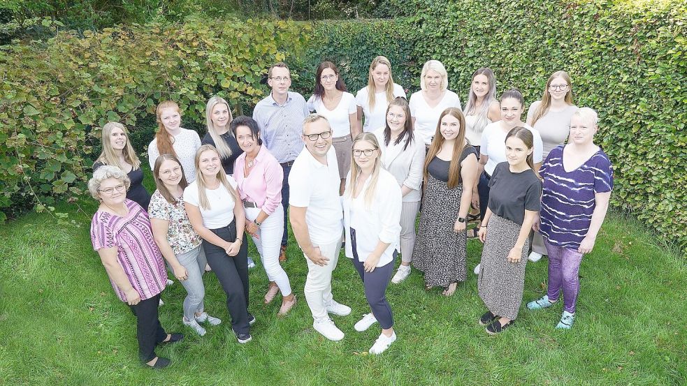 Gruppenbild im Garten: Waldemar Asnaimer und seine Frau Olga (vordere Reihe, Mitte) mit einem Großteil des Teams. Künftig ist die Kanzlei auch in Rhauderfehn vertreten. Foto: privat