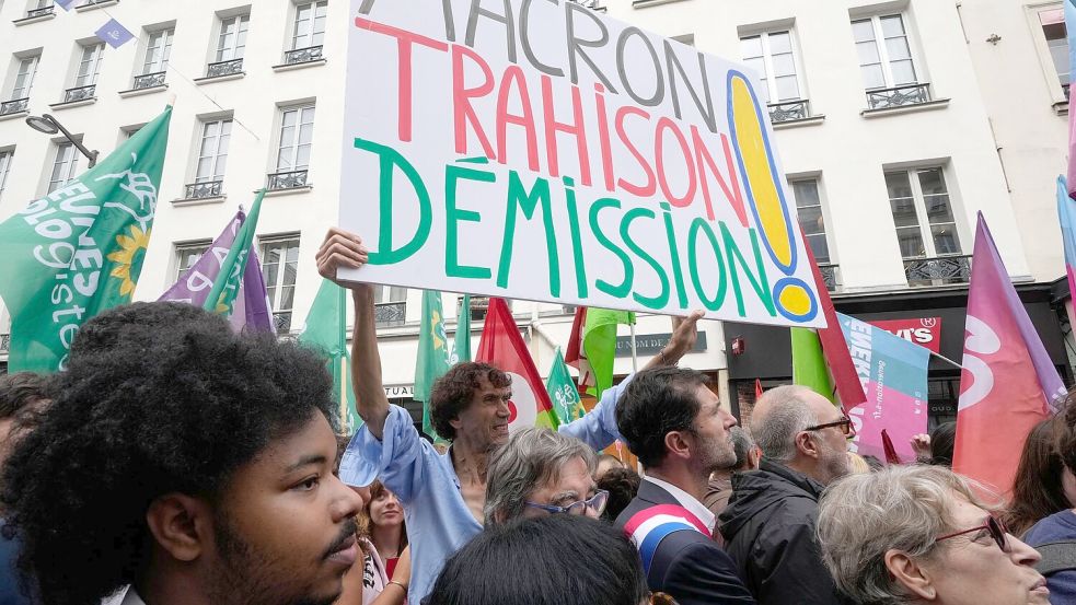 „Rücktritt von Macron - Verrat“ wird auf einem Plakat auf einer Demonstration in Paris gefordert. Foto: Michel Euler/AP/dpa