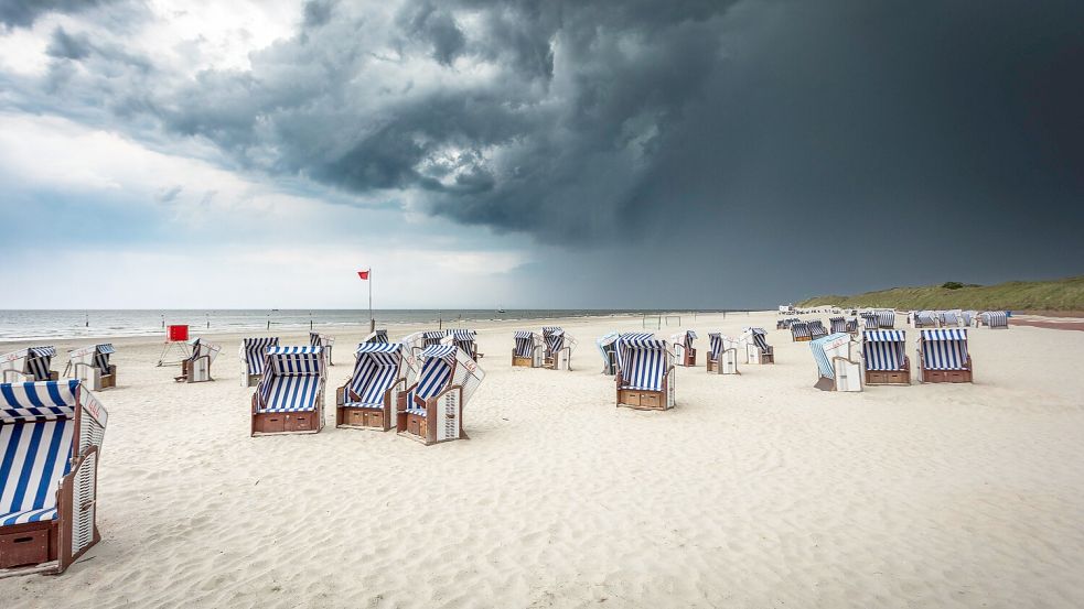 Düstere Gewitterwolken über dem Nordstrand von Norderney: Der Spätsommer verabschiedet sich. Foto: IMAGO/Priller&Maug