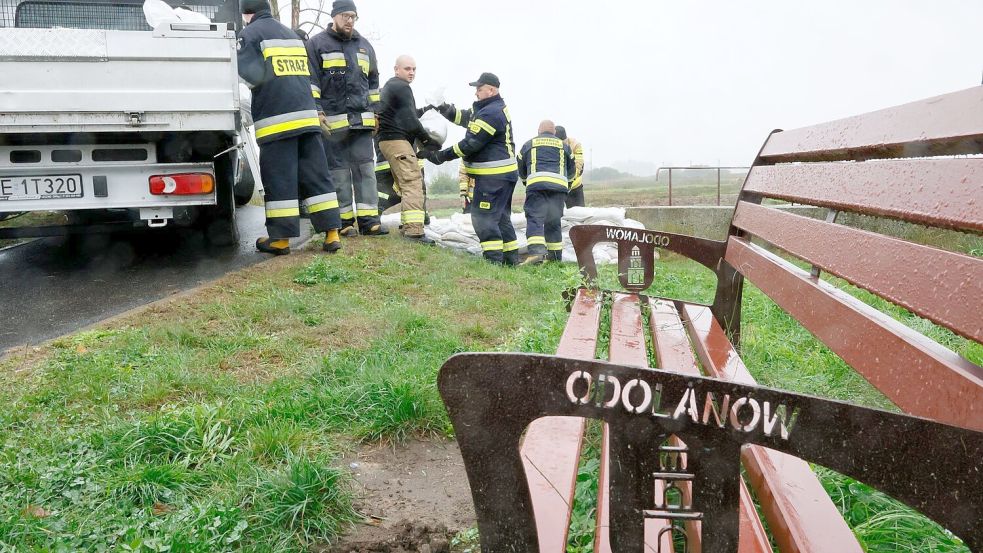 Feuerwehrleute in Polen errichten mit Sandsäcken eine Barriere gegen das drohende Hochwasser in der Nähe des Flusses Barycz in Odolanow. Foto: Tomasz Wojtasik/PAP/dpa