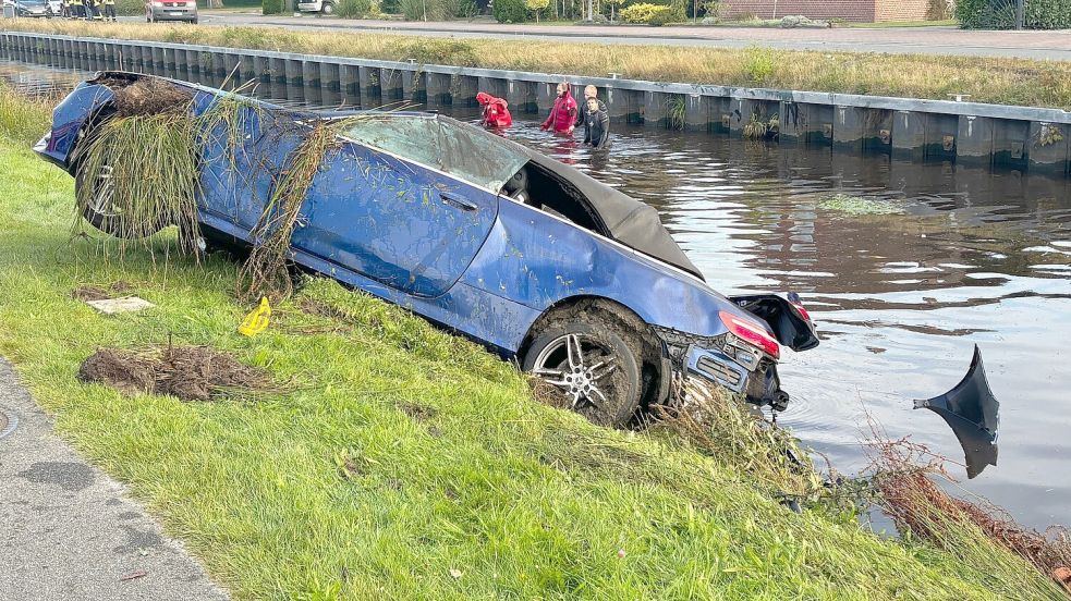 Die Feuerwehr zog den Wagen, der zunächst kopfüber im Kanal lag, mit Hilfe von Stahlseilen und einer Winde auf die Böschung des Kanals am Untenende. Unterdessen suchten Helfer im Kanal (hinten) nach möglichen weiteren Personen, da zunächst nicht klar war, wie viele Insassen sich im Unfallwagen befunden haben. Foto: Ammermann