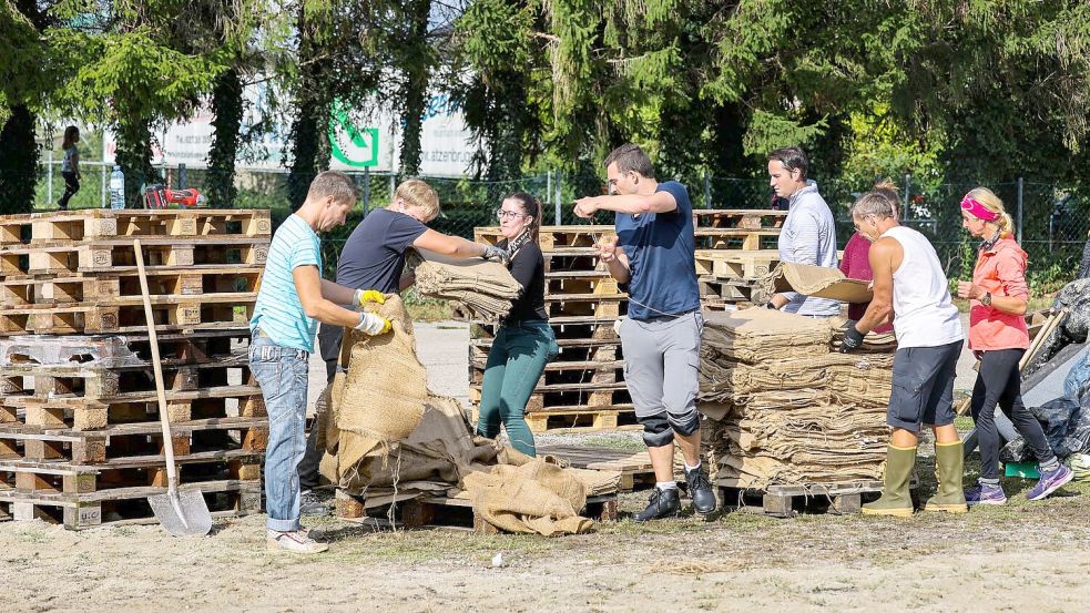 In Österreich helfen Freiwillige beim Befüllen von Sandsäcken. Foto: Christoph Reichwein/dpa