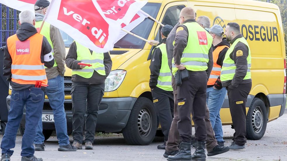 Teilnehmer eines Streiks stehen vor einer Niederlassung von Prosegur in Hamburg. Foto: Bodo Marks/dpa