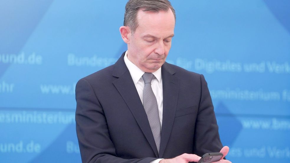 Bundesverkehrsminister Volker Wissing (FDP) blickt bei einer Pressekonferenz im März 2022 auf sein Smartphone. Foto: Joerg Carstensen/dpa