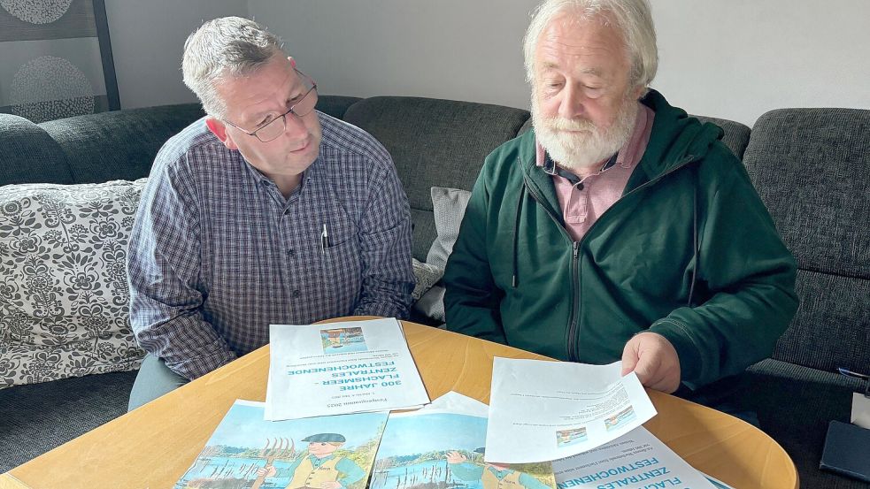 Heimatforscher Hans-Gerd Voßkuhl (rechts) und Ernst-Ingo Lind gehören zum Organisationsteam. Das Teams bereitet das Jubiläum 300 Jahre Flachsmeer vor. Vor Voßkuhl und Lind liegen Zeichnungen des neuen Maskottchens „Harm“. Foto: Ammermann