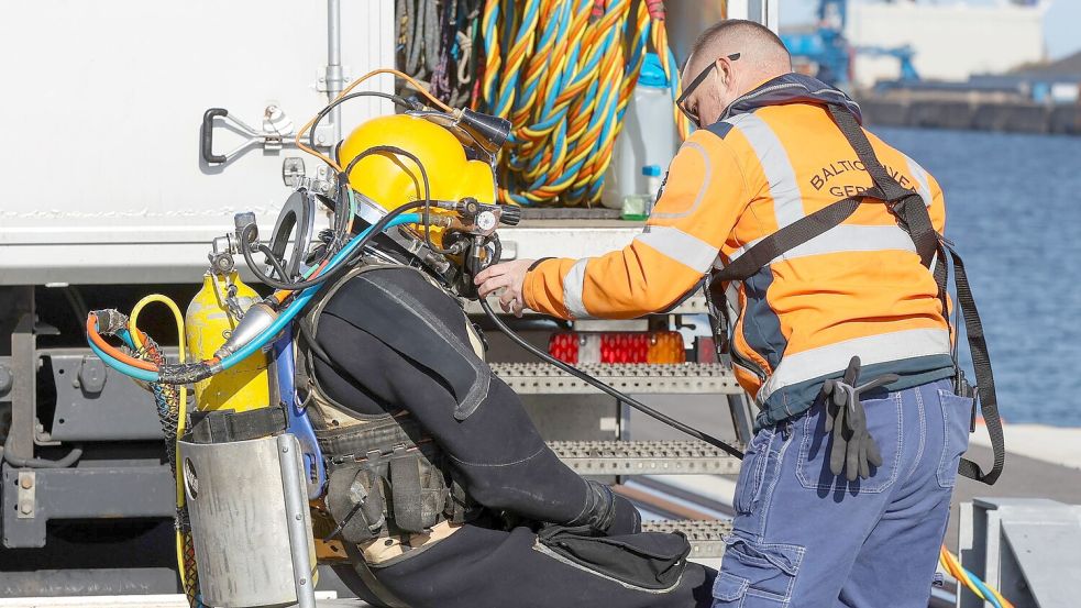 Ein Taucher macht sich im Rostocker Hafen startklar, um den Rumpf des nach einem Brand havarierten Öltankschiffes „Annika“ zu kontrollieren. Foto: Bodo Marks/dpa