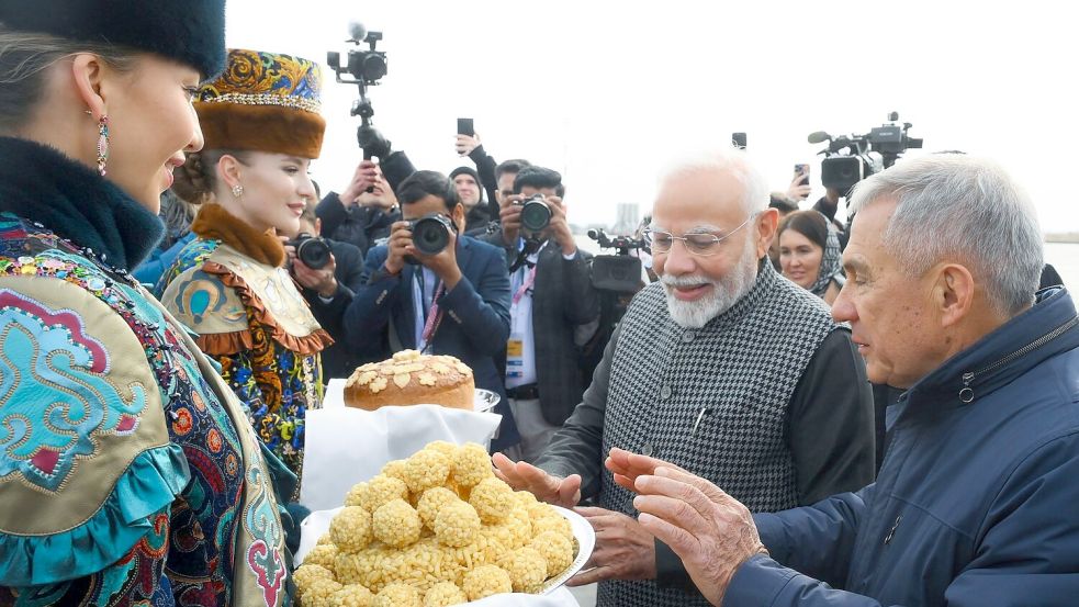 Der indische Premierminister Narendra Modi (2. v. r.) probiert bei seiner Ankunft am Flughafen von Kasan eine traditionelle tatarische Süßigkeit. Foto: Ilya Pitalev/brics-russia2024.ru via AP/dpa