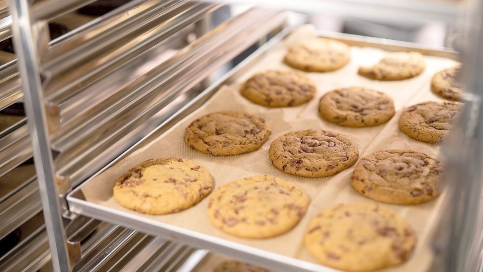 Frisch aus dem Ofen kommen die Cookies - und werden dann noch belegt. Foto: Christoph Schmidt/dpa