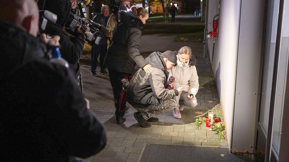 Anwohner legen Blumen und Kerzen nieder. Foto: Christophe Gateau/dpa