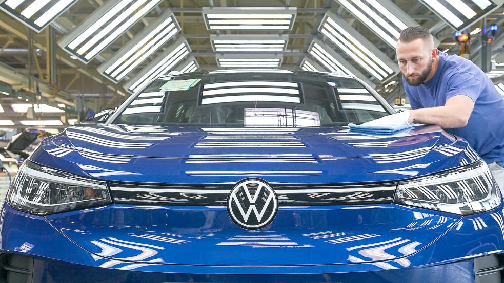 Mensch und Marke: Ein Mitarbeiter im Volkswagenwerk in Zwickau kontrolliert im sogenannten Finish einen VW ID.4 im Lichttunnel. Foto: picture-alliance/dpa-Zentralbild